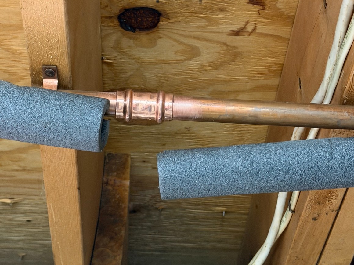 Repaired copper water line and press fitting in a home