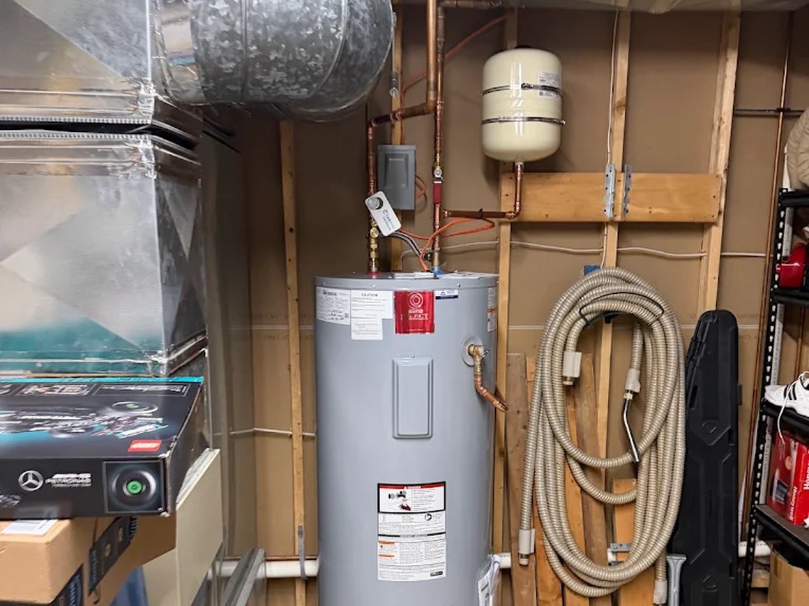 Electric water heater installed by Carter Quality Plumbing with a supported expansion tank.