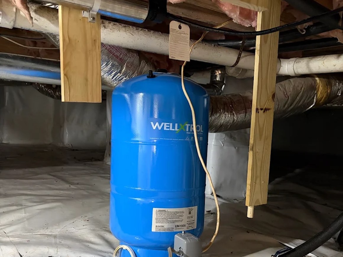 Blue well pressure tank installed in a crawlspace
