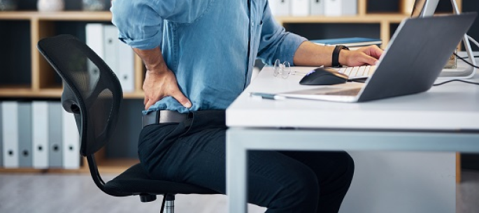 Office worker with back pain and daytime fatigue caused by poor, sleep-deprived nights
