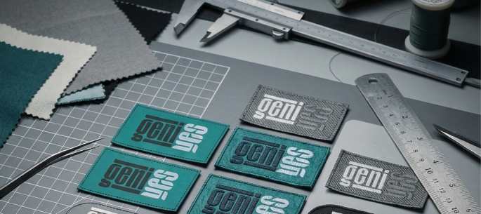 GeniYes woven brand labels for the Sleepmaxxer sleep mask laid out during production