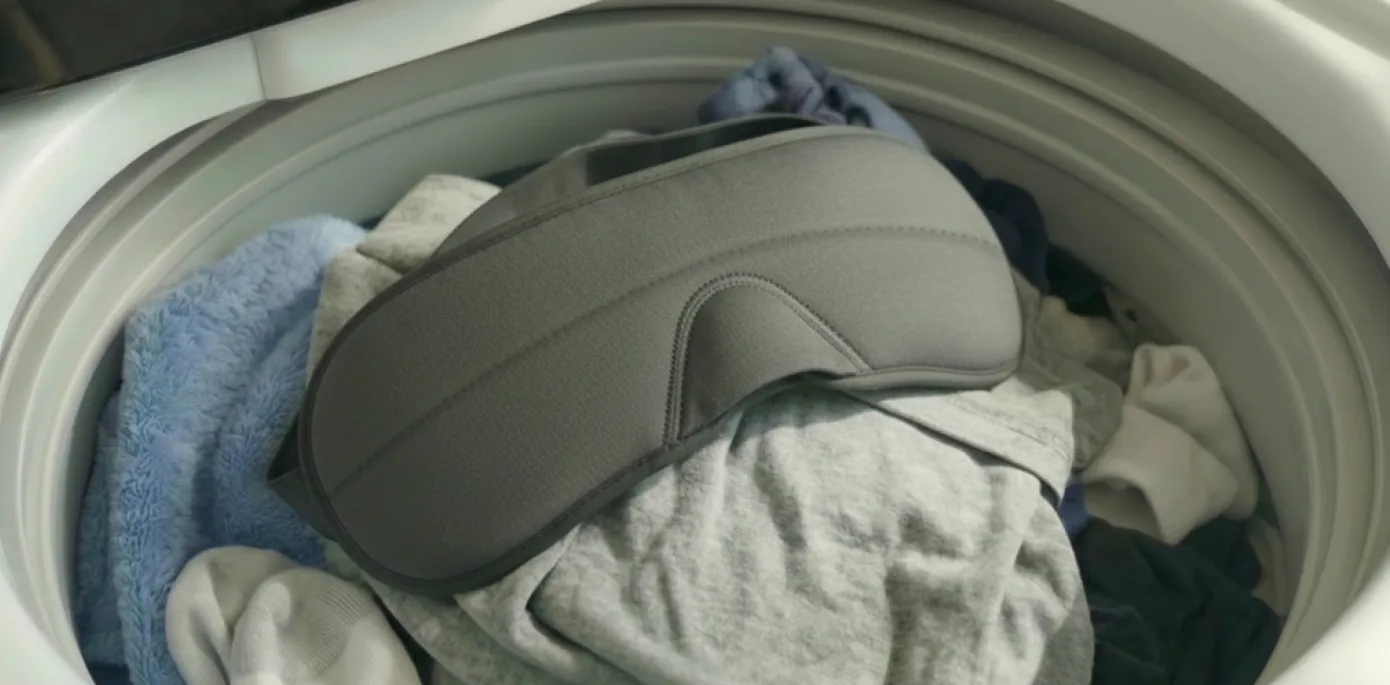 Sleepmaxxer sleep mask tumbling in a washing-machine drum, showing it is fully machine washable