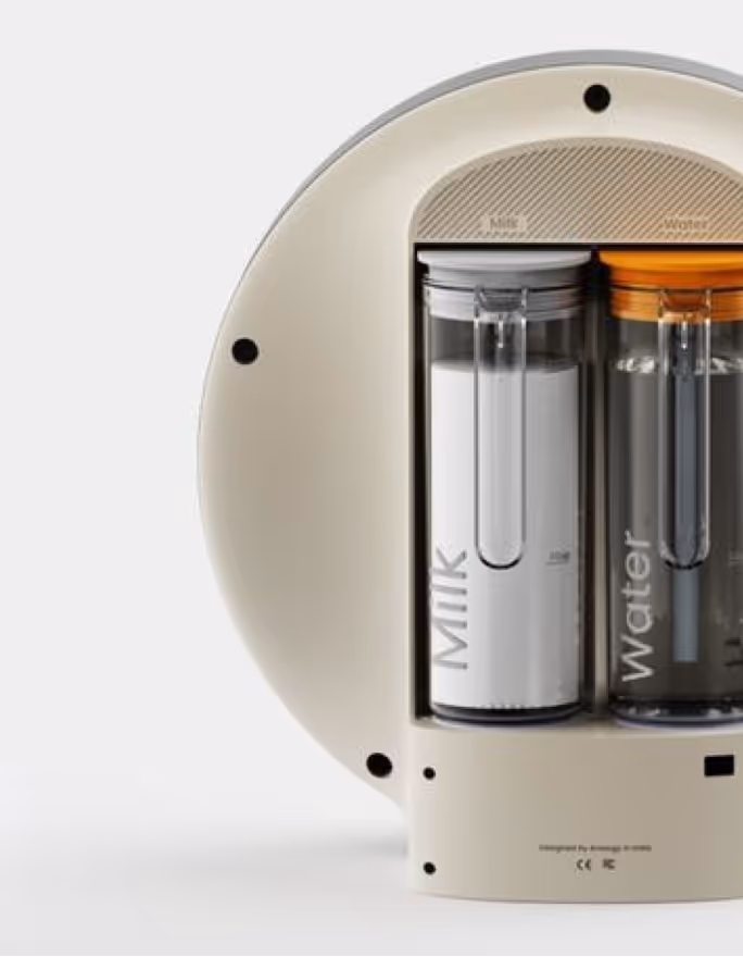 Close-up of the Dostea tea maker with clear milk and water tanks and a cream body
