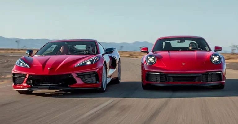 Red Chevrolet Corvette C8 and red Porsche 911 driving side by side on a desert highway