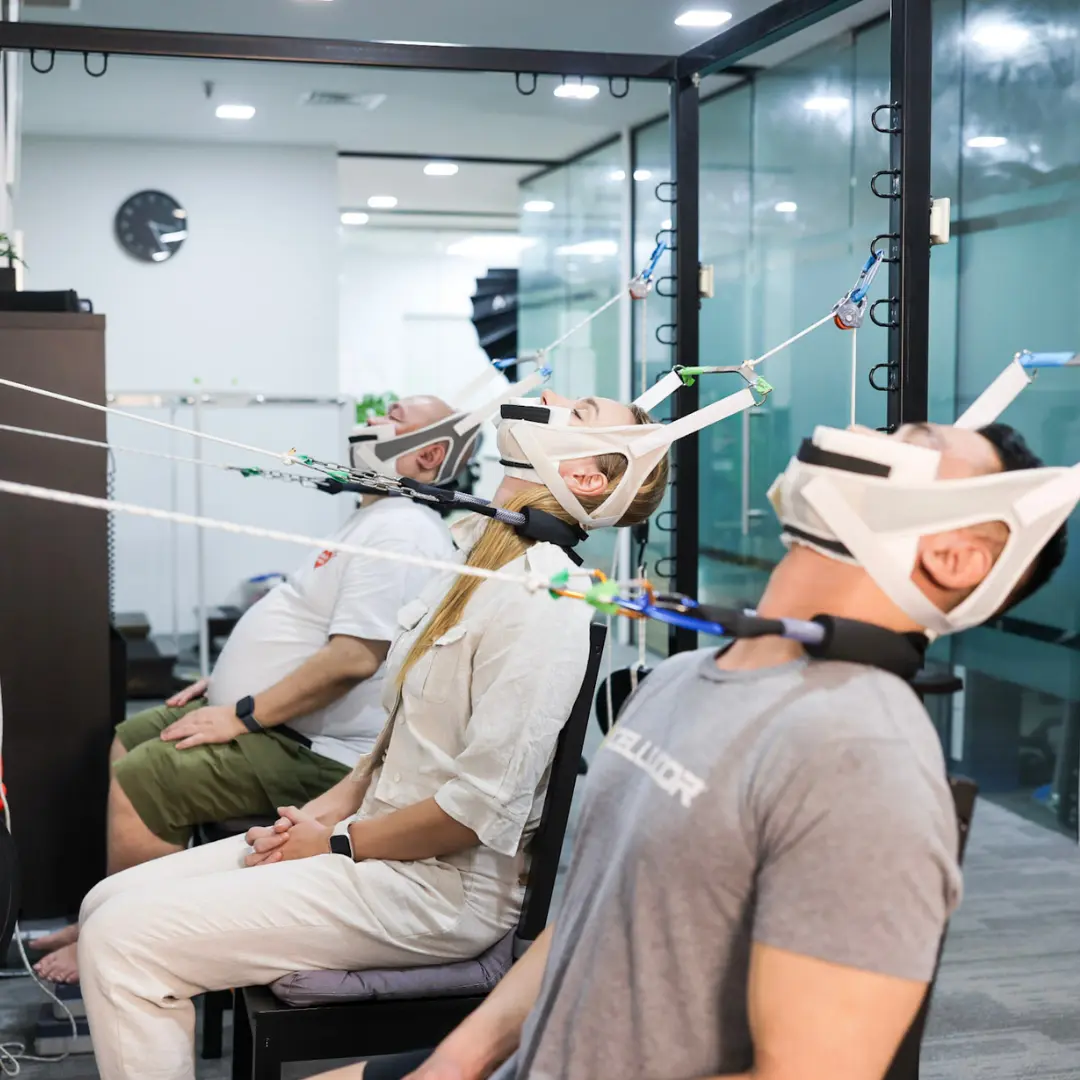 Patients utilising advanced vertical and horizontal cervical traction equipment during the release phase of the R3NEW X protocol for permanent neck curve correction