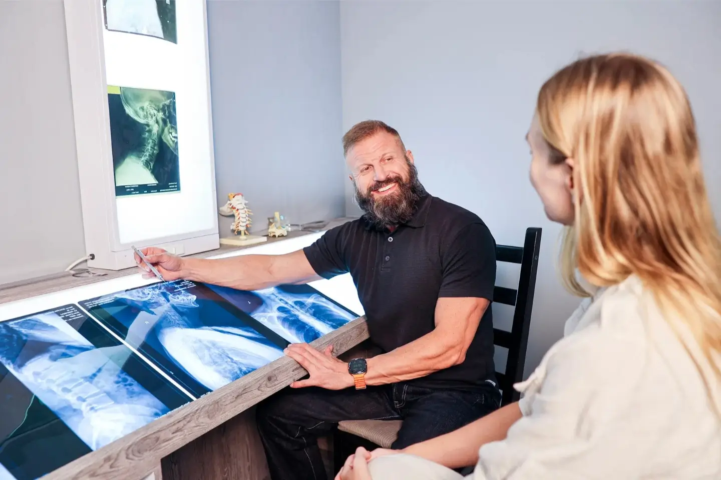 Dr Will Kalla analysing cervical spine X-rays with a patient to evaluate structural neck alignment