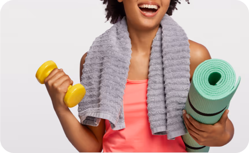 Sportlich gekleidete Frau mit Hantel, Yogamatte und Handtuch – symbolisiert Rückenschmerzen, Bandscheibenprobleme und Wirbelsäulenbeschwerden.