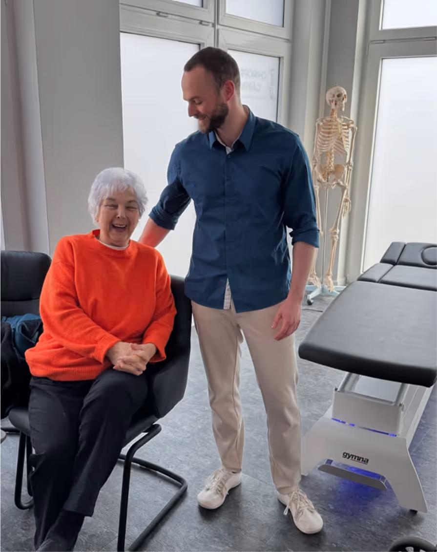 Sven Gärtner im Gespräch mit Patientin in der Chiropraxis Gärtner Braunschweig – ganzheitliche, menschliche Chiropraktik mit Fokus auf persönliche Betreuung.