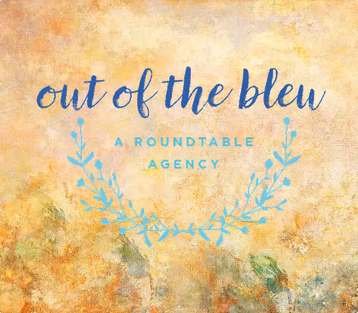 Logo with the phrase 'out of the bleu' in blue script and 'A ROUND TABLE AGENCY' below, decorated with a blue leafy wreath on a textured beige and light orange background.