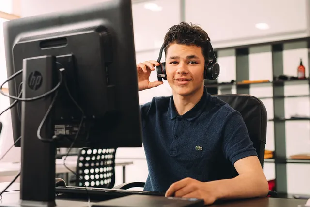 Jongen bij Sales Kings Nederland die actief bezig is met klantenbenadering met een koptelefoon op