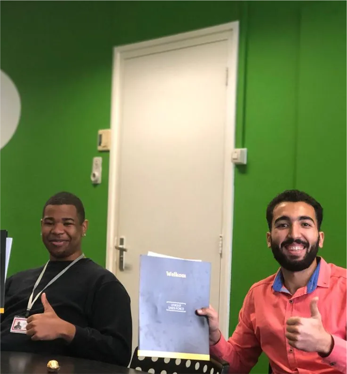 Twee mannelijke medewerkers bij Sales Kings Nederland die lachen met hun duim omhoog