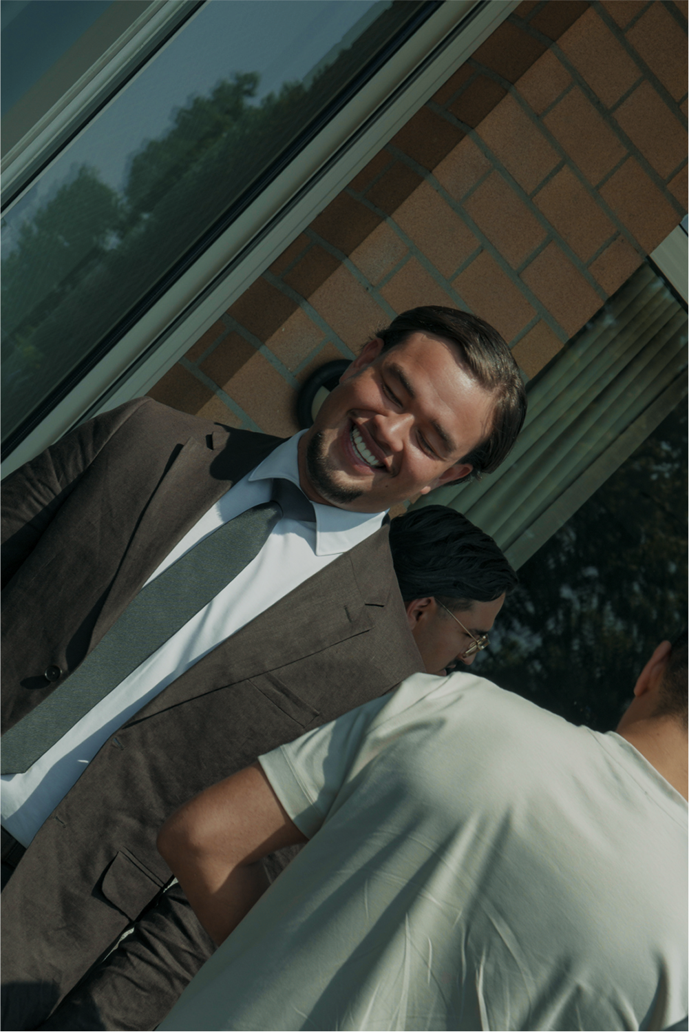 Lachende jongeman in zijn pak die blij is met zijn nieuwe salesbaan