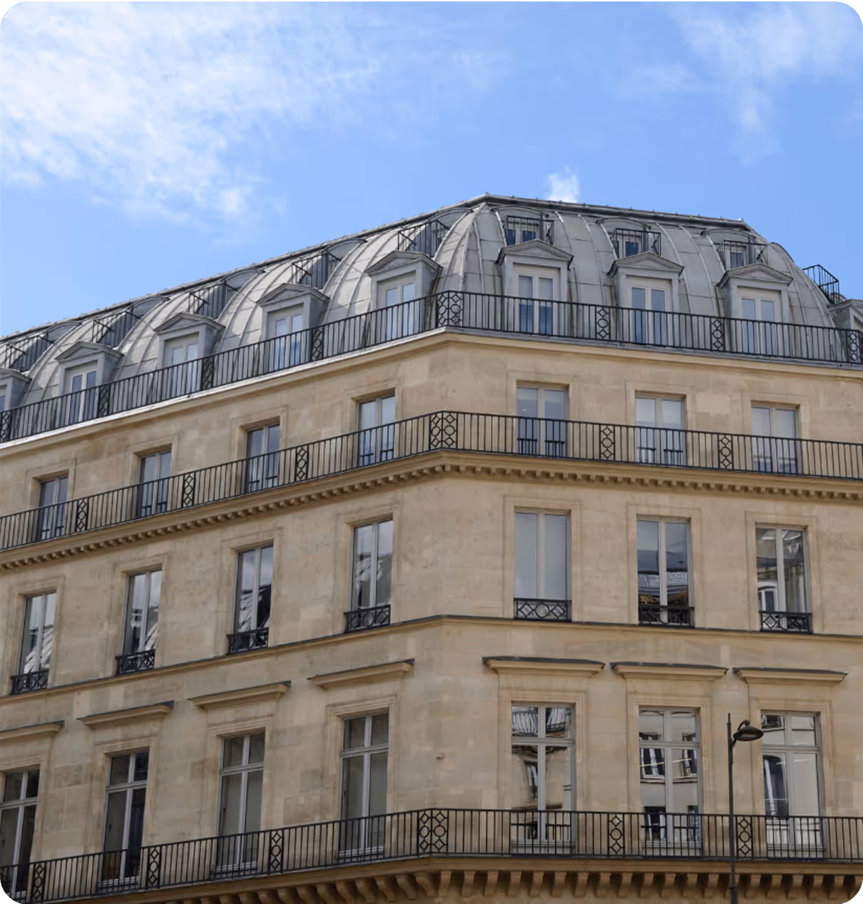 Un immeuble d'angle haussmannien avec un toit en ardoise à Paris