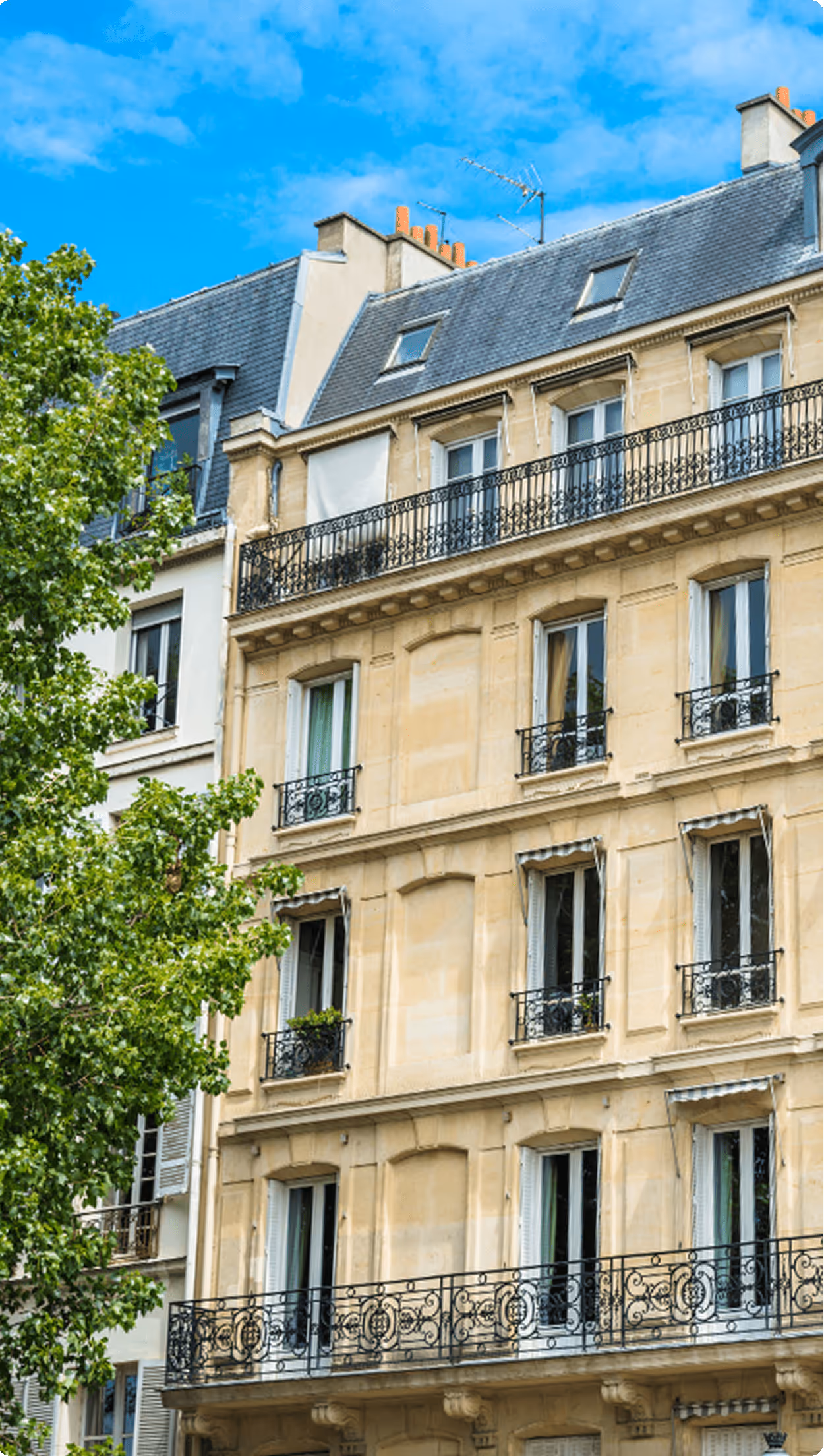 Un immeuble parisien de style haussmannien avec des balcons en fer forgé