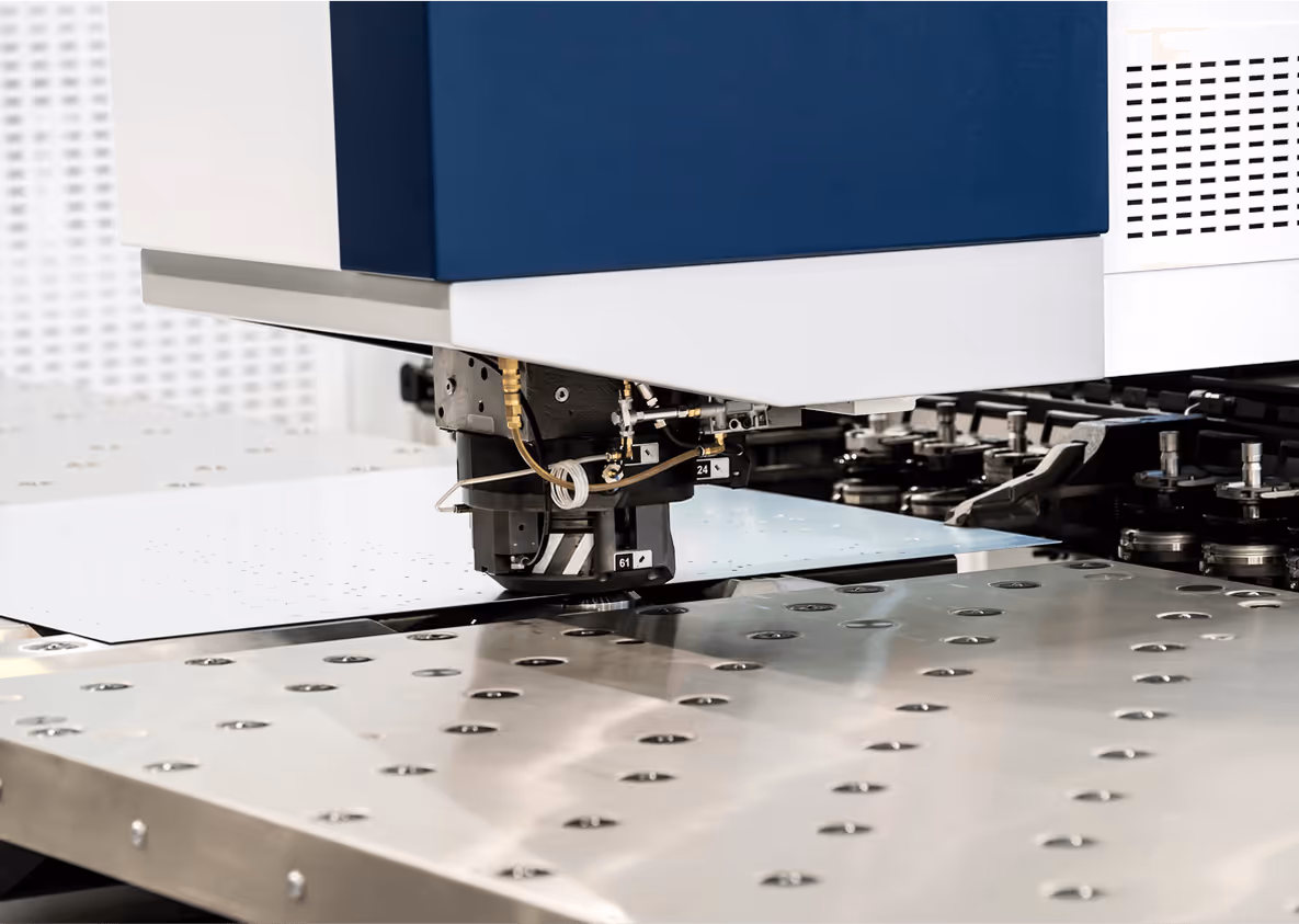 Maschine stanzt Metallplatte, moderne industrielle Fertigung, präziser Metallbearbeitungsprozess.