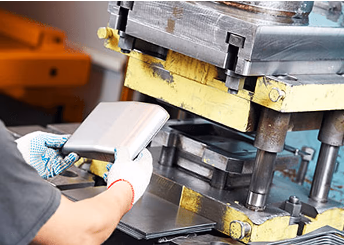 Industrielle Metallpresse verarbeitet Metallplatte, Arbeiter mit weißen Handschuhen positioniert Material.