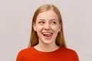 A young woman is smiling and making a funny face.