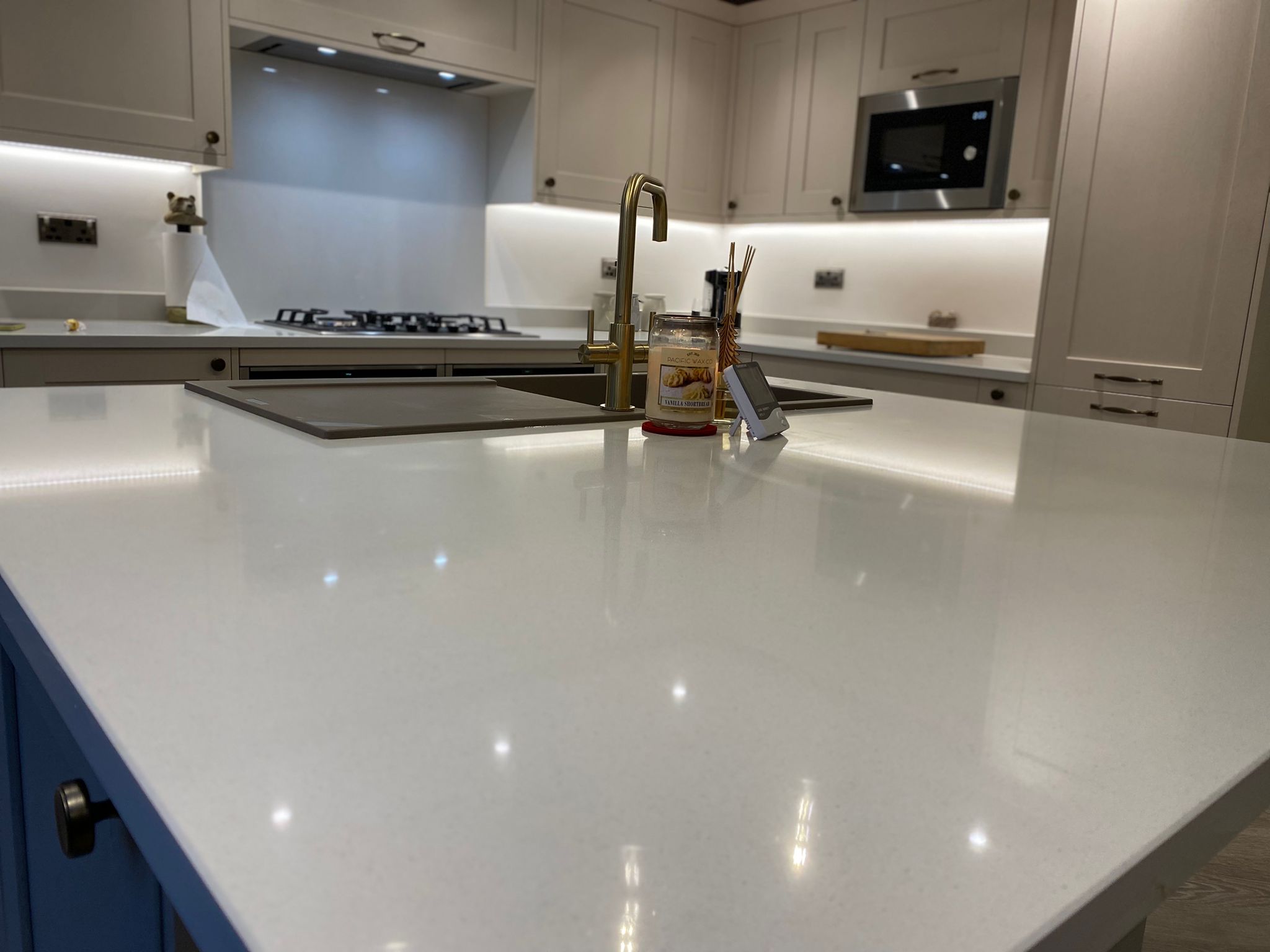Quartz kitchen island with gold tap and modern appliances – Project Managed Kitchens renovation.