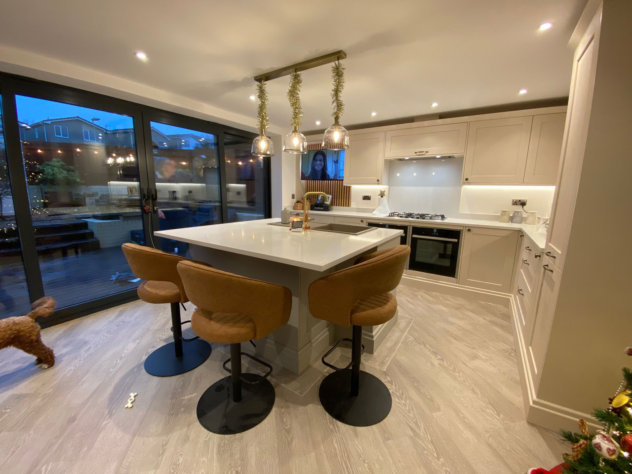 Modern open-plan kitchen with large island, pendant lighting, and seating for three.