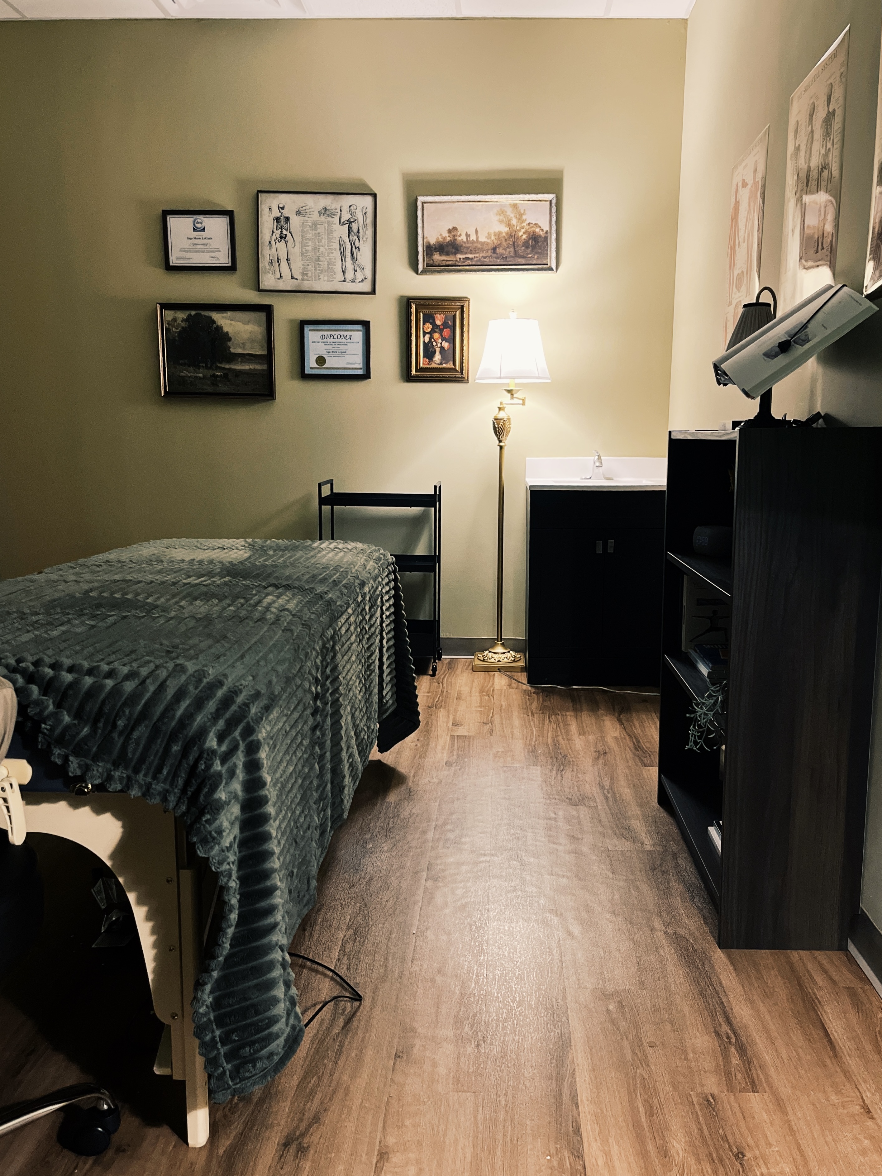 Peaceful massage studio in Milwaukee featuring warm lighting, natural decor, and a soft green massage table for therapeutic bodywork sessions.