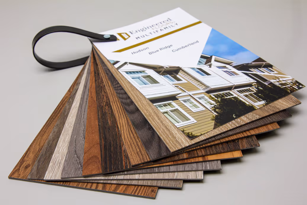 Sample kit of engineered wood flooring options with a cover showing houses and product names.
