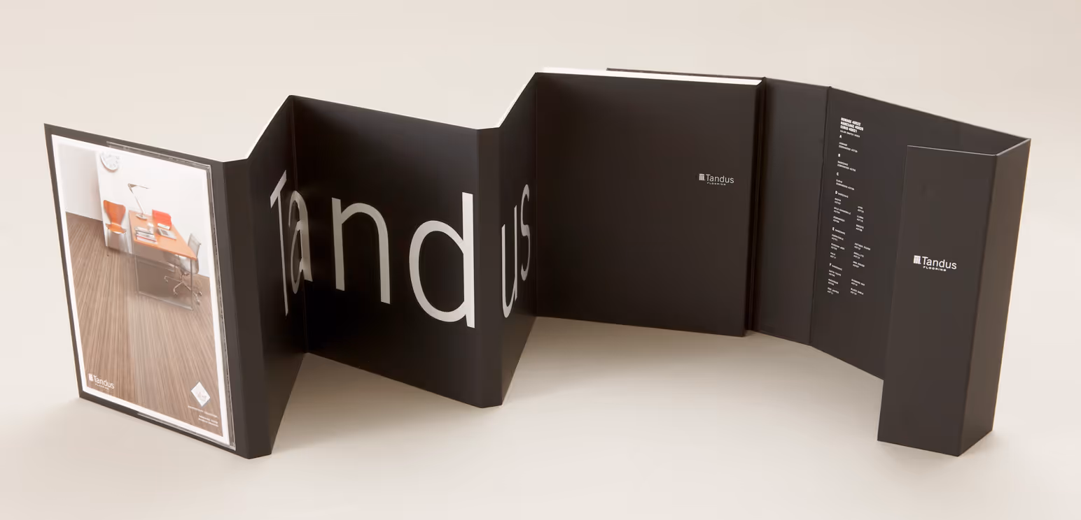 Black folding brochure for Tandus Flooring with office image and white text on cover and inside.