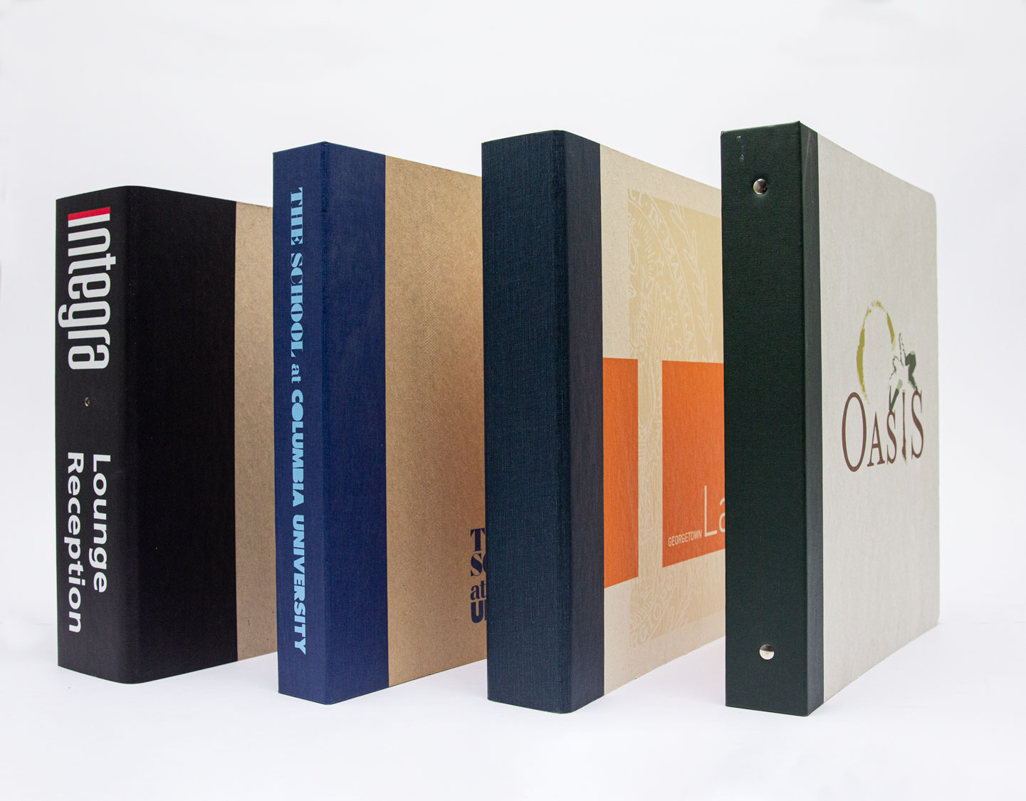 Four standing binders, each with distinct colored spines and printed text or logos facing left.