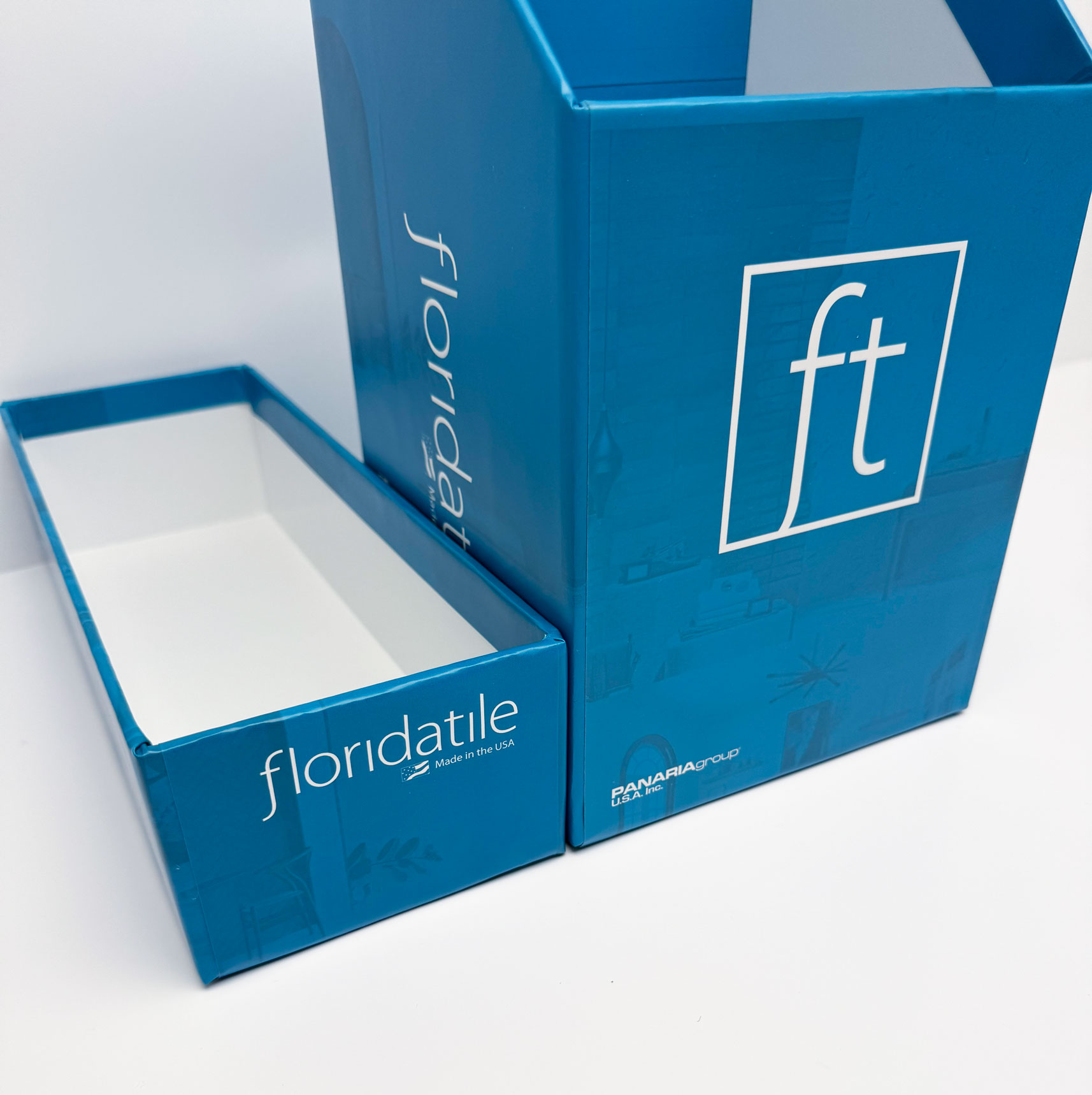 Blue Floridatile box and lid with white interior and branding on a white background.