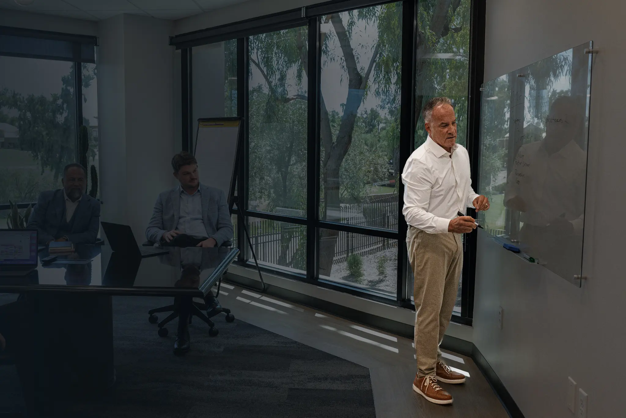 A man standing in front of a glass wall.