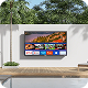 Smart TV mounted on an outdoor wall above a wooden bench in a patio area.