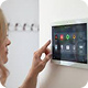 Person using a wall-mounted smart home control panel.