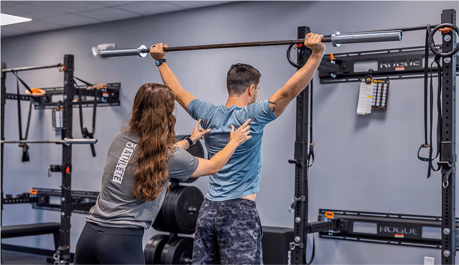 Sports physical therapist working with athlete on sport-specific rehabilitation in Wilmington, NC clinic