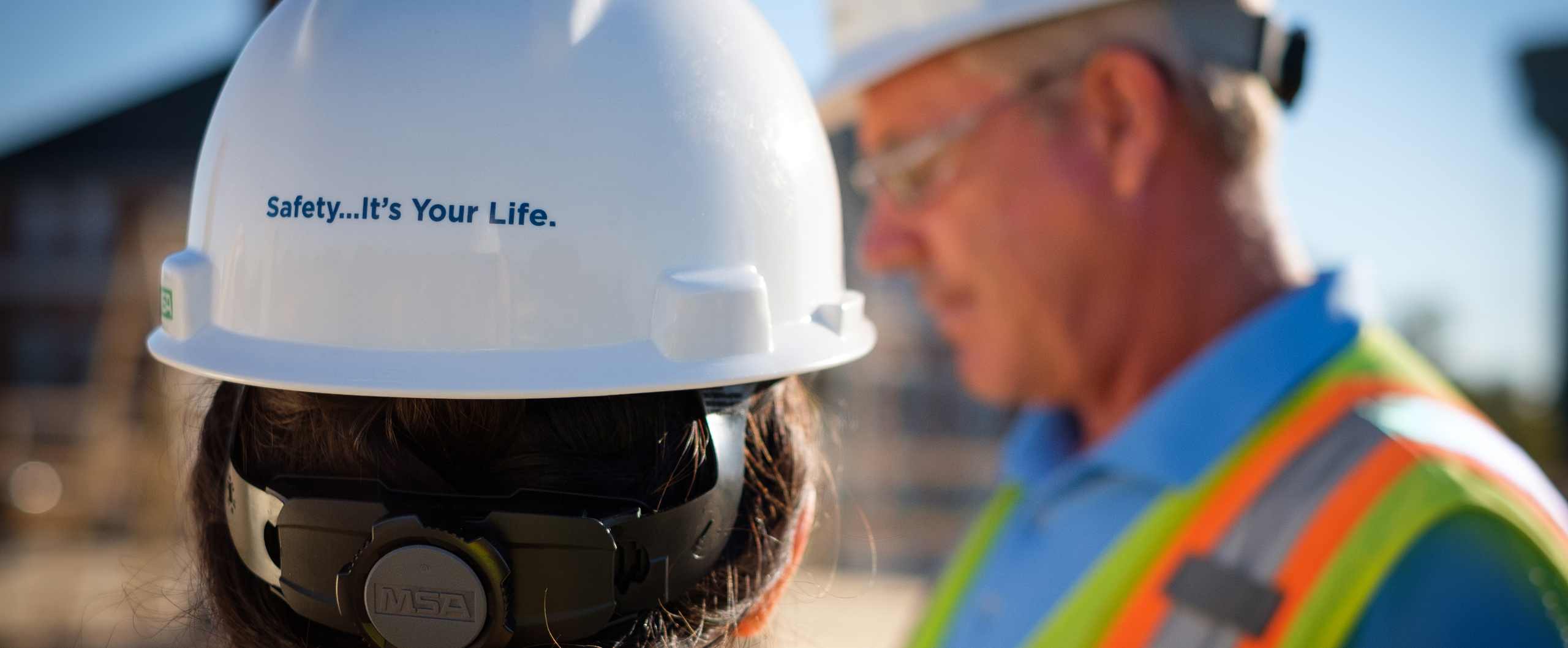 Two construction workers wearing hard hats on the job.