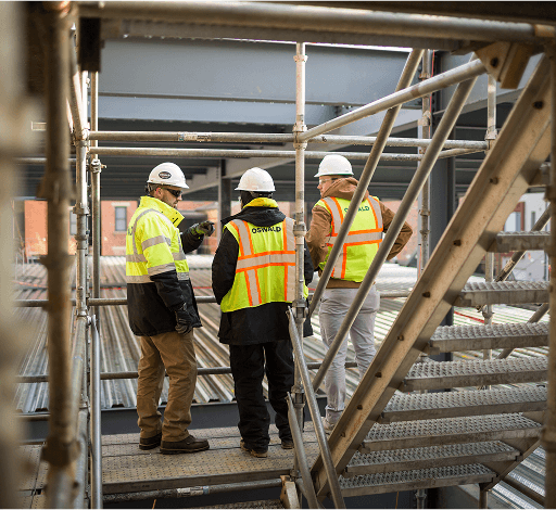 3 construction workers on a staircase.