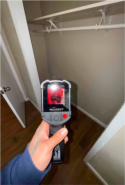 Thermal imaging camera scanning a closet wall for hidden moisture