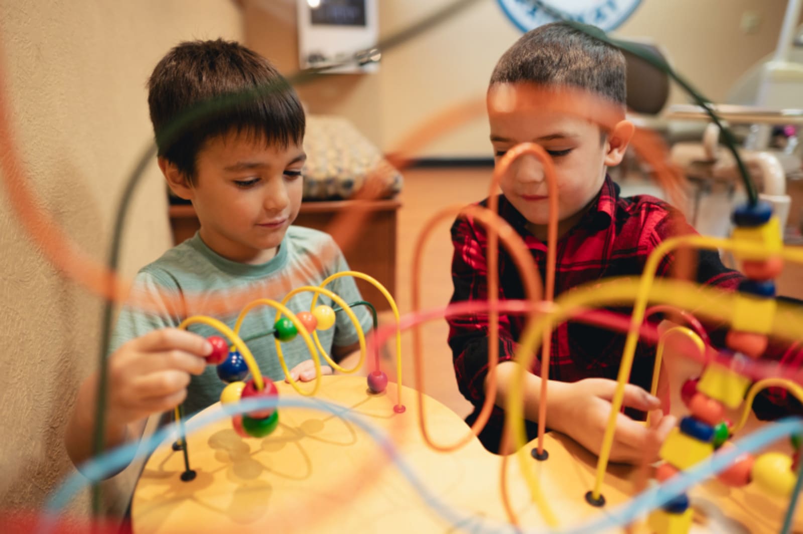 Children playing with colorful bead maze toy in the waiting room