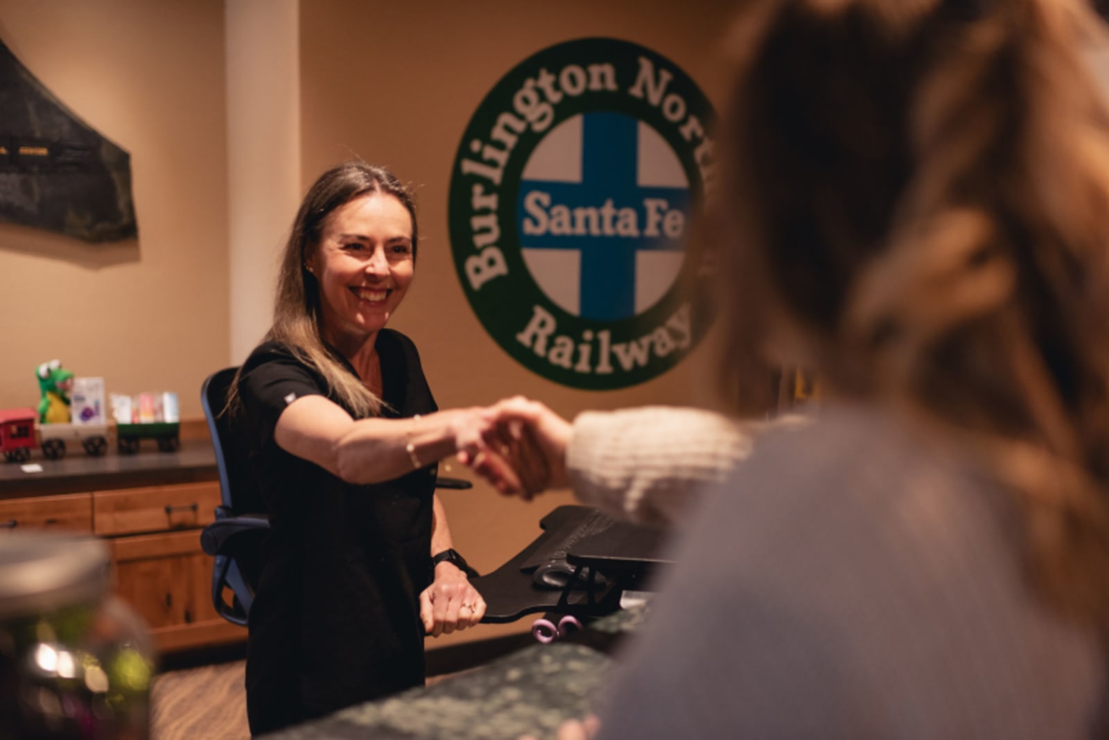 Female dentist demonstrating orthodontic treatment to a patient in a dental office setting.