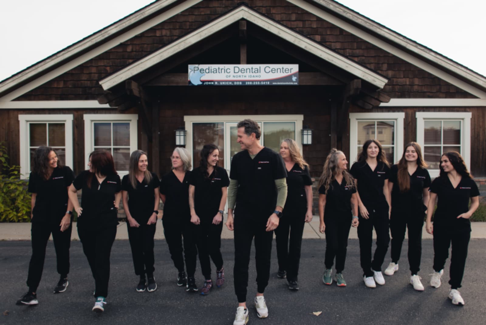 Pediatric Dental Center of North Idaho team smiling outside their Coeur d'Alene office building.