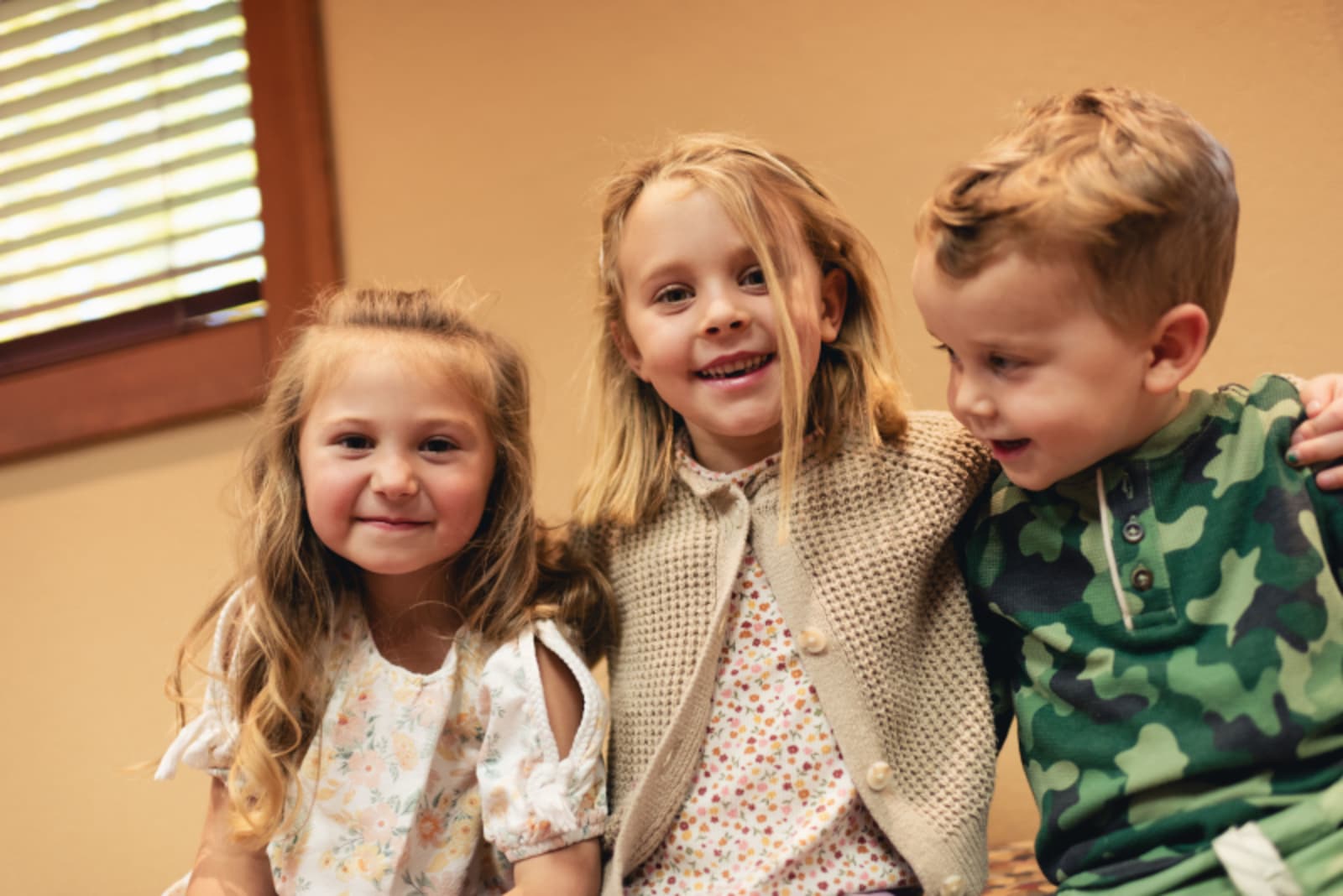 Three smiling children in a dental office, comfortable and happy during their visit