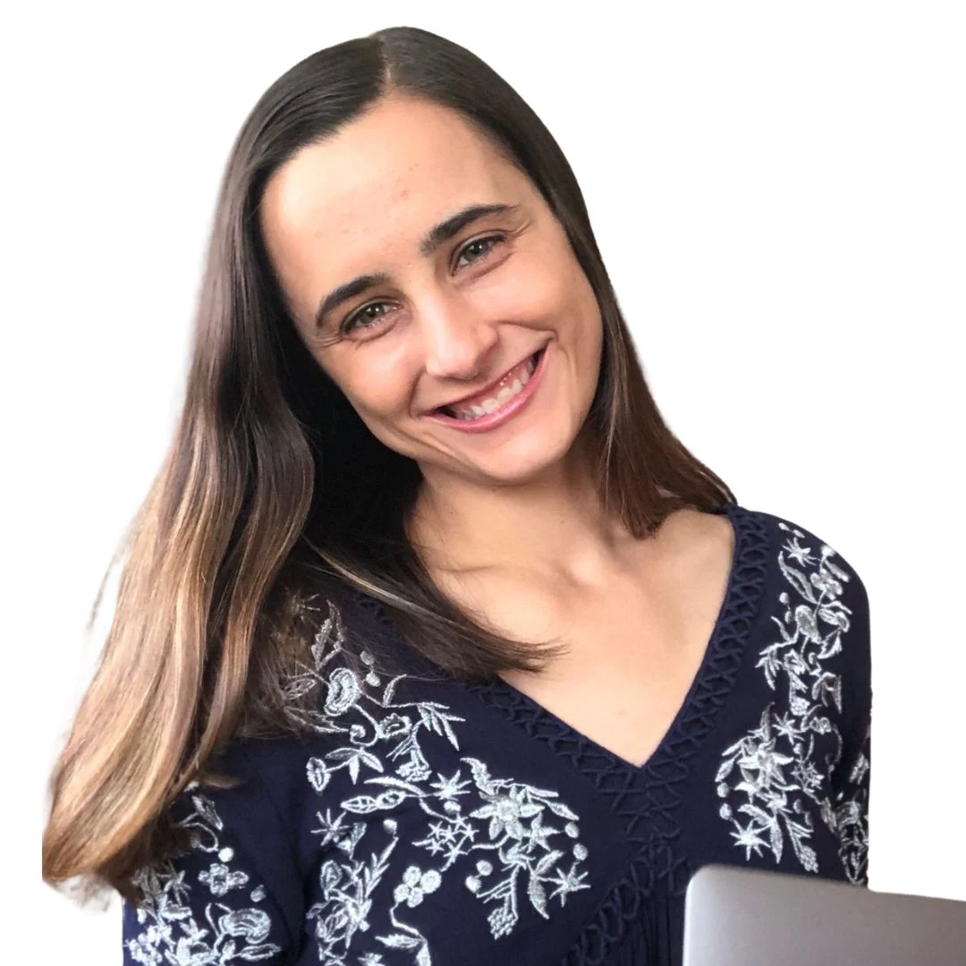 Smiling woman with long brown hair wearing a navy blue top with white floral embroidery.