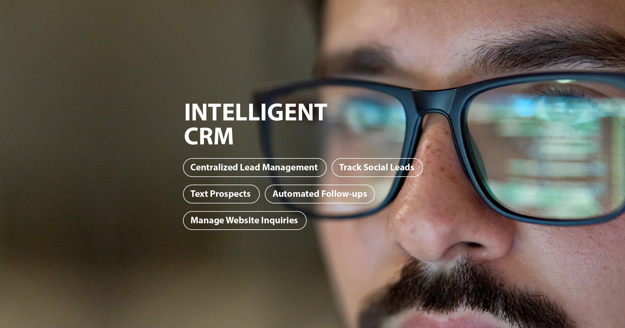 Close-up of man with glasses reflecting computer code and text about intelligent CRM features.
