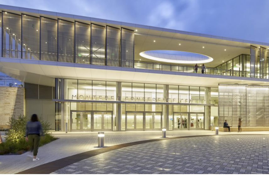 Modern building with glass facade and circular ceiling opening at Montebello Conference Center entrance.