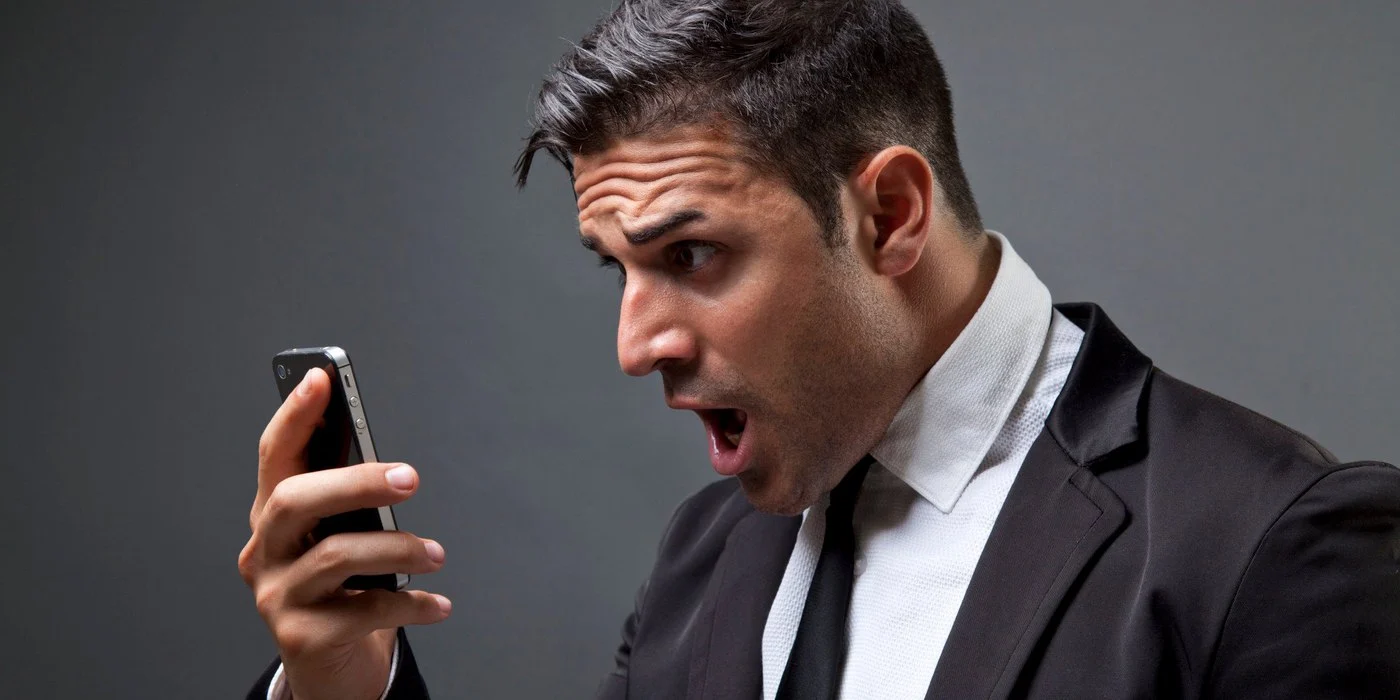 A shocked man looking at his phone