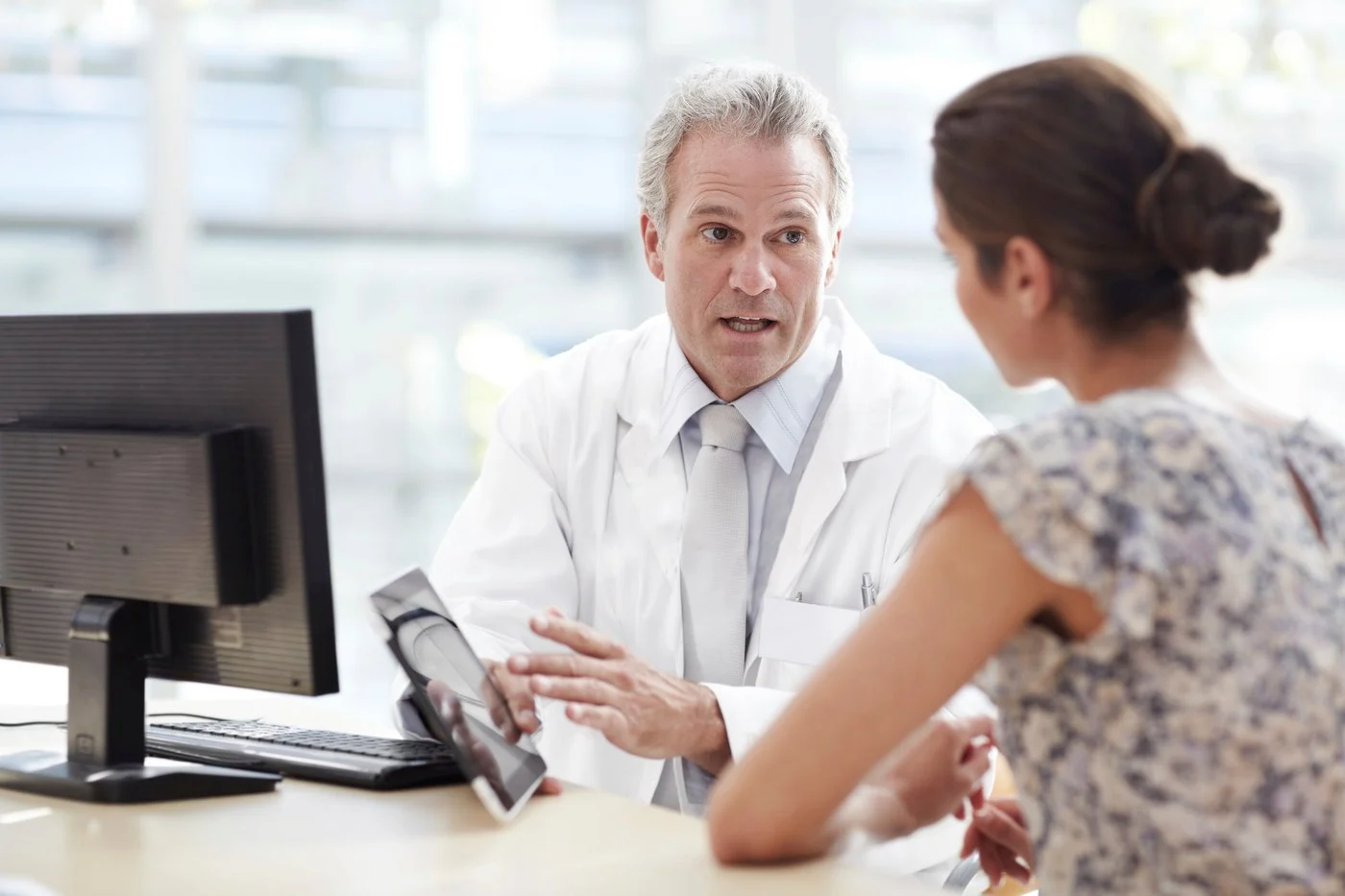A healthcare professional showing a patient something on a tablet device