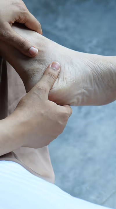 Woman in Los Angeles rubs heel, considering custom orthotics and regenerative therapy for lasting relief from heel pain.