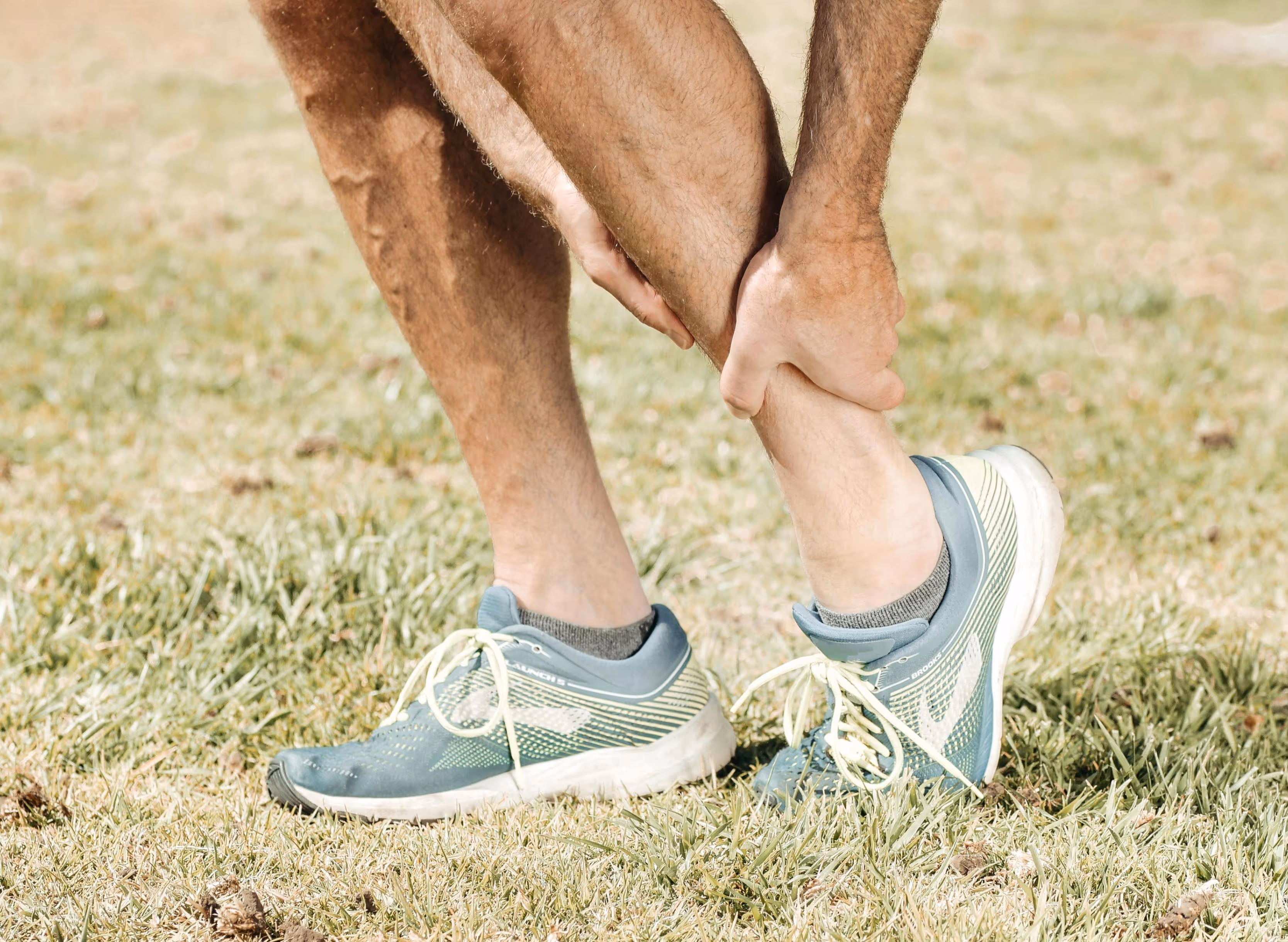 Man in Los Angeles stands on grass, highlighting ankle fracture symptoms, and causes.