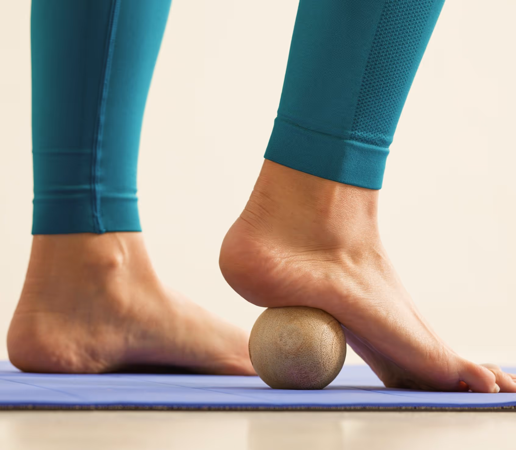 Woman in Los Angeles uses therapy ball on yoga mat to relieve pain, restore mobility, and avoid surgical intervention.