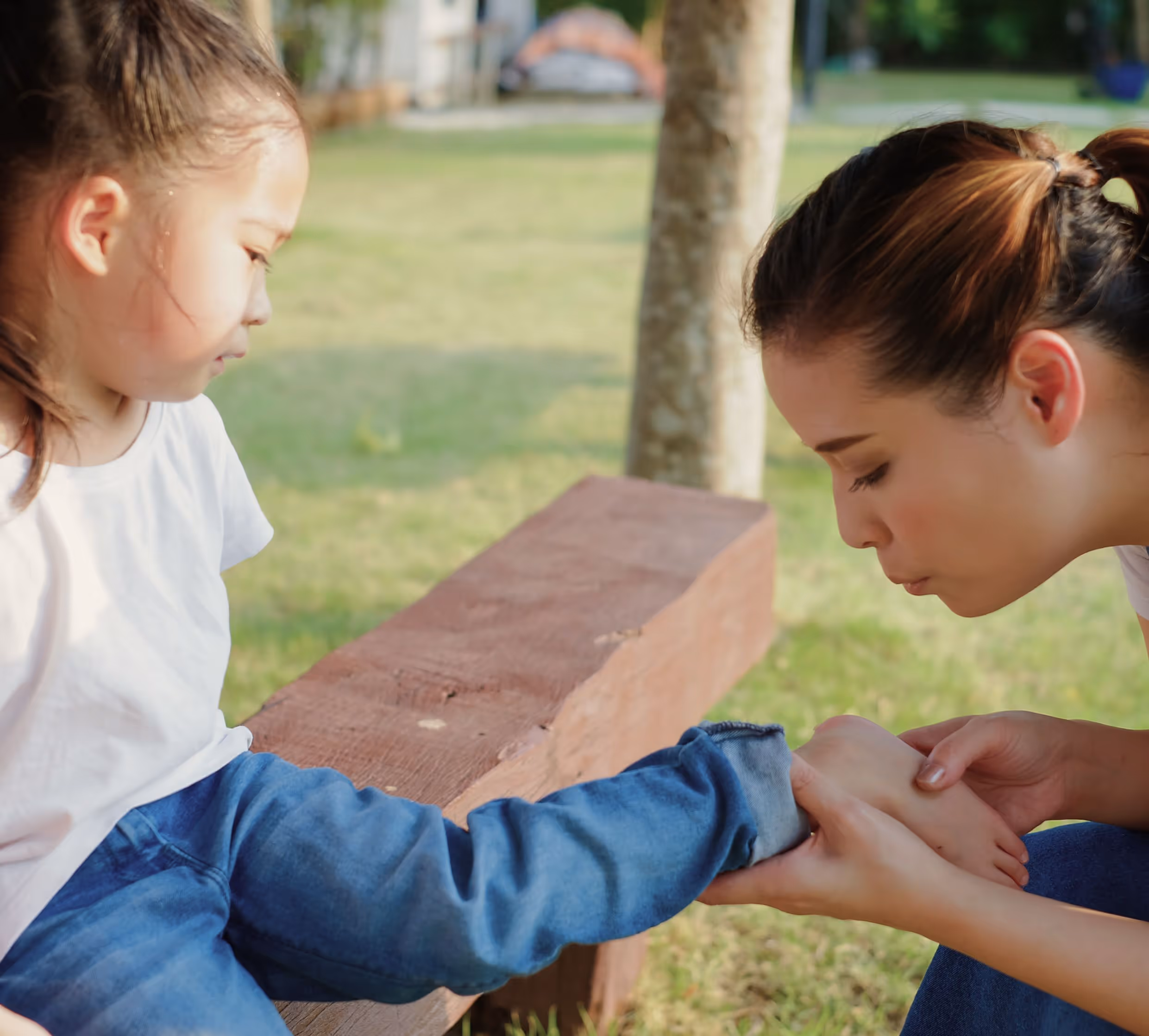 Woman and girl on bench in Los Angeles displaying common pediatric sports injuries.