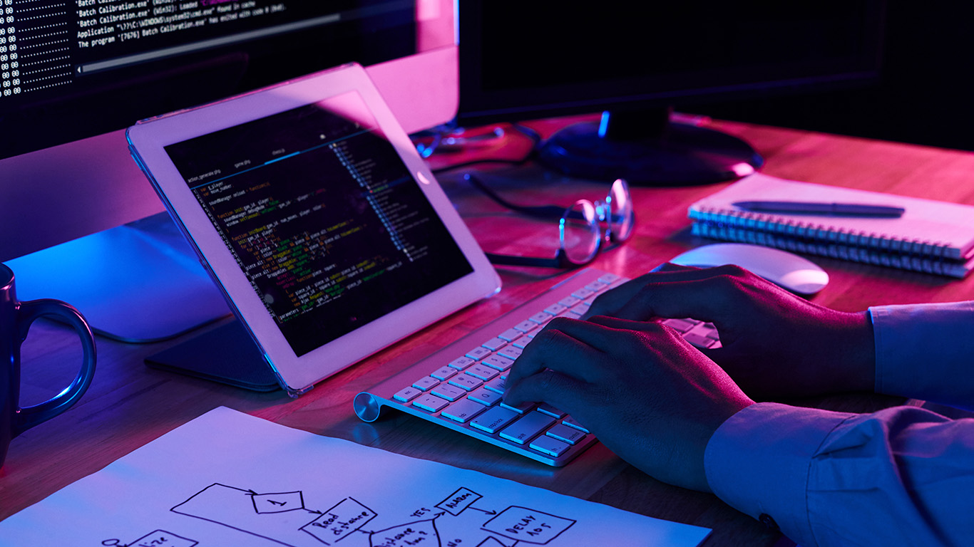 Oficina corporativa moderna minimalista (estética sobria), laptop premium mostrando una interfaz de un diseño web en colombia limpia y contundente.