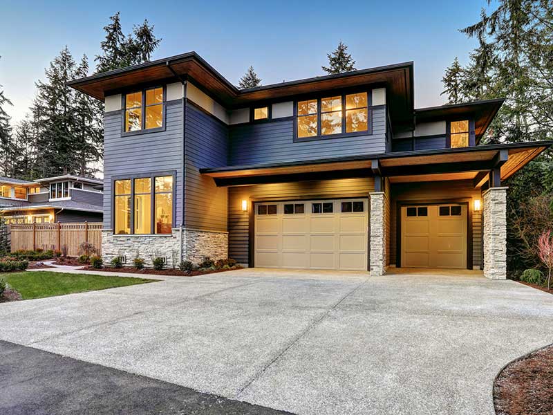 A modern home with textured siding and a double garage